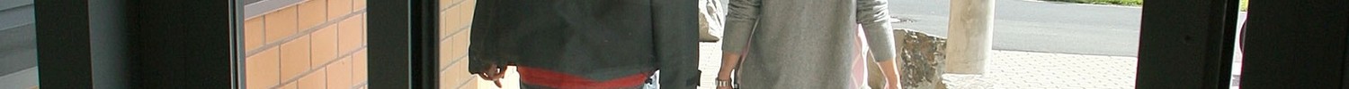 Ein Mann und eine Frau laufen nebeneinander aus einer gläsernen Tür. (Bild: LWL/Cord)