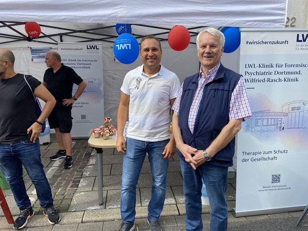 Zwei Männer stehen am Infostand der Wilfried-Rasch-Klinik (Bild: LWL/SchuFi)