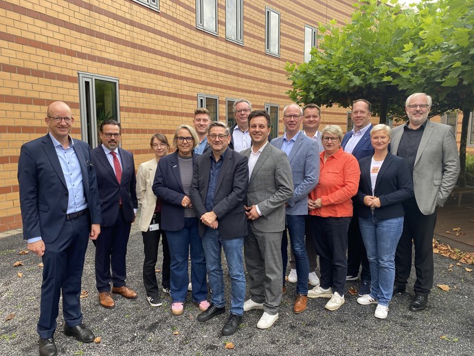 Ein Gruppe von Männern und Frauen steht in einem Innenhof und lächelt in die Kamera. (Bild: LWL/SchuFi)