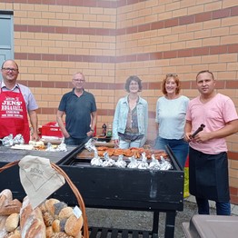Drei Männer und zwei Frauen stehen mit Grillzangen hinter einem Grill. (Bild: LWL)