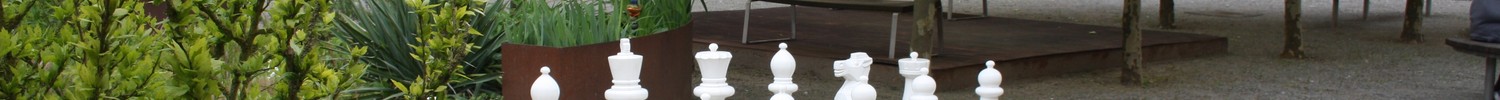 Blick auf ein Outdoor-Schachspiel in einem begrünten Innenhof. (Bild: LWL)
